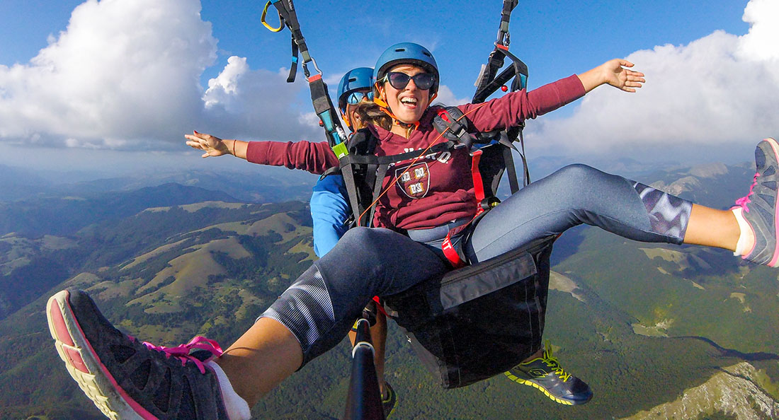 Ragazza felice di volare in parapendio con cloud hunters a Norma